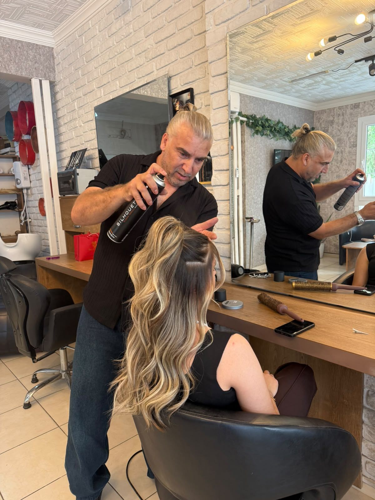Kuaför, uzun balayage saça sprey ile son şeklini veriyor